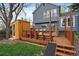 Backyard view with a wooden deck, a wooden sauna, grass, and a blue two-story home at 8508 Vivian Ct, Arvada, CO 80005