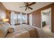 Well-lit main bedroom with plush carpet, ceiling fan, and access to an ensuite bathroom at 8508 Vivian Ct, Arvada, CO 80005