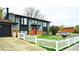 Charming two-story home with gray siding, red door, brick accents and a white picket fence creating a welcoming curb appeal at 1528 Coronado Pkwy, Denver, CO 80229