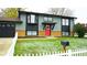 Charming two-story home with gray siding, a red door and a white picket fence adding to its inviting curb appeal at 1528 Coronado Pkwy, Denver, CO 80229