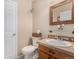 Cozy bathroom with wood-framed mirror, updated vanity, and neutral paint at 11613 W Coal Mine Dr, Littleton, CO 80127