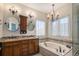 Large bathroom with double vanity sinks, bathtub, and modern lighting fixtures at 11613 W Coal Mine Dr, Littleton, CO 80127