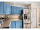 Stainless steel refrigerator and ample counter space complement the blue cabinets in this kitchen at 11613 W Coal Mine Dr, Littleton, CO 80127