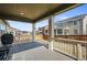 Covered back porch features a wooden railing and serene backyard view, perfect for outdoor relaxation at 14881 Chicago St, Parker, CO 80134