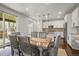 Well-lit dining room with a wooden table, upholstered chairs, and access to the kitchen and outdoor patio at 14881 Chicago St, Parker, CO 80134