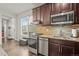 Kitchenette featuring stainless steel appliances, hardwood floors, and dark cabinets at 14881 Chicago St, Parker, CO 80134