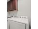Well-equipped laundry room with modern washer and dryer, alongside ample storage in the upper cabinetry at 14881 Chicago St, Parker, CO 80134