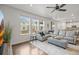 Bright living room features hardwood floors, a large sectional sofa, and plenty of natural light from several windows at 14881 Chicago St, Parker, CO 80134