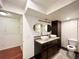 Bathroom with dual sinks, modern fixtures, dark wood cabinets, and tile flooring, providing a stylish and functional space at 20532 E Lake Cir, Centennial, CO 80016