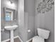 Compact half bathroom featuring modern fixtures and a sleek pedestal sink at 20532 E Lake Cir, Centennial, CO 80016