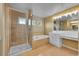 Well-lit bathroom featuring a glass enclosed shower, soaking tub, and vanity with a large mirror at 20532 E Lake Cir, Centennial, CO 80016