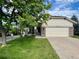 Charming home featuring a well-manicured lawn, mature tree, and a two-car garage, creating a welcoming curb appeal at 20532 E Lake Cir, Centennial, CO 80016
