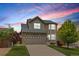 Two-story home with brick and siding, a two-car garage, and a well-manicured lawn at 5733 S Yakima Way, Aurora, CO 80015
