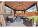 A covered gazebo with comfortable wicker furniture and a blue rug, creating an inviting outdoor space at 5733 S Yakima Way, Aurora, CO 80015