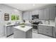 Modern kitchen featuring stainless steel appliances, an island, and sleek gray cabinetry at 5733 S Yakima Way, Aurora, CO 80015