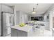 Bright, open-concept kitchen with a kitchen island, stainless steel fridge, and dining area at 5733 S Yakima Way, Aurora, CO 80015