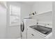 Bright laundry room with a modern washer and dryer and ample storage on a shelf above the appliances at 5733 S Yakima Way, Aurora, CO 80015