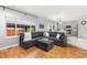 Open living room with a grey sectional sofa, hardwood floors, and a view to the kitchen at 5733 S Yakima Way, Aurora, CO 80015