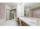 Bathroom featuring pink tile, dual sinks, large mirror and a separate bathtub at 9873 Greensview Cir, Lone Tree, CO 80124