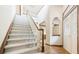 Bright foyer showcases a carpeted staircase and hardwood flooring at 9873 Greensview Cir, Lone Tree, CO 80124