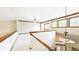 Hallway boasts natural light, wood trim and banister, and contemporary chandelier at 9873 Greensview Cir, Lone Tree, CO 80124