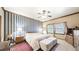 Bedroom featuring blue striped wallpaper, sitting stools, lamps, and a large bed at 9873 Greensview Cir, Lone Tree, CO 80124