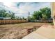 Large, unfenced backyard with fresh dirt, mature trees and a concrete patio at 3055 Carson St, Aurora, CO 80011