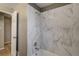 Newly tiled white marbled bathtub and shower at 3055 Carson St, Aurora, CO 80011