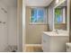 Bathroom featuring a vanity with storage, updated fixtures, shower, and a bright window at 3055 Carson St, Aurora, CO 80011