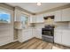 Bright kitchen with white cabinets, a new stove and oven, and new laminate flooring at 3055 Carson St, Aurora, CO 80011