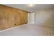 Spacious living room featuring light-colored carpet, and an accent wall made of wood paneling at 3055 Carson St, Aurora, CO 80011