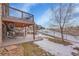 Scenic backyard view featuring a covered patio, metal fence, rock landscaping, and a partial view of a pond at 27615 E Moraine Dr, Aurora, CO 80016