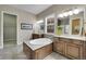 Bright bathroom features a soaking tub, double vanity, and a separate shower with gray tile surround at 27615 E Moraine Dr, Aurora, CO 80016