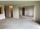 Open living area with neutral carpet, offering a versatile layout for customization and featuring access to other rooms in the home at 13601 E Marina Dr # 508, Aurora, CO 80014