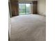 Bright living room featuring a sliding glass door to a balcony and neutral carpet, ready for personalization and offering outdoor views at 13601 E Marina Dr # 508, Aurora, CO 80014