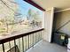 View from balcony with black metal railing overlooking green space and mature trees in a well-maintained community at 8625 Clay St # 228, Westminster, CO 80031