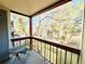 Balcony view with wrought iron railing overlooking the lawn and trees, furnished with bistro table and chairs at 8625 Clay St # 228, Westminster, CO 80031