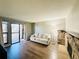 Cozy living room with wood floors, sliding glass doors to a balcony, and a stone fireplace at 8625 Clay St # 228, Westminster, CO 80031