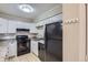 Well-lit kitchen featuring white cabinets, granite countertops, and black appliances for a modern look at 2280 S Oswego Way # 104, Aurora, CO 80014