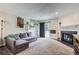 Cozy living room featuring a fireplace, plush carpet, and a sliding door to the outside at 2280 S Oswego Way # 104, Aurora, CO 80014