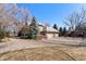 A spacious home featuring a long driveway leading to a three-car garage, surrounded by mature trees and well-maintained landscaping at 4160 S Humboldt St, Cherry Hills Village, CO 80113