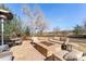 Relaxing backyard patio area with a stone fire pit, comfortable seating, and a view of the lush, green landscape at 4160 S Humboldt St, Cherry Hills Village, CO 80113