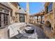 A cozy outdoor patio with a stone fireplace, curved wicker seating, a pergola, and a view of the beautiful stone home at 4160 S Humboldt St, Cherry Hills Village, CO 80113