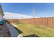 Large backyard with a grassy area, concrete patio, and a wood fence at 5530 Lewiston Ct, Denver, CO 80239