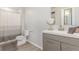 Well-lit bathroom featuring modern vanity, decorative mirror, and shower with curtain at 5530 Lewiston Ct, Denver, CO 80239