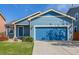 Beautifully-kept blue home features a front yard with established landscaping and attached garage at 5530 Lewiston Ct, Denver, CO 80239