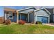 Charming blue home featuring a well-manicured lawn, front entry porch and attached garage at 5530 Lewiston Ct, Denver, CO 80239