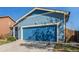 Exterior of home showcasing the 2 car garage with blue doors and exterior lighting at 5530 Lewiston Ct, Denver, CO 80239