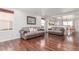 Open-concept living room with hardwood floors, neutral decor, and an adjoining kitchen and dining area at 5530 Lewiston Ct, Denver, CO 80239
