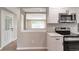Bright kitchen with white cabinets, quartz countertops and stainless steel appliances overlooking the living area at 8280 Auburn Ln, Westminster, CO 80031